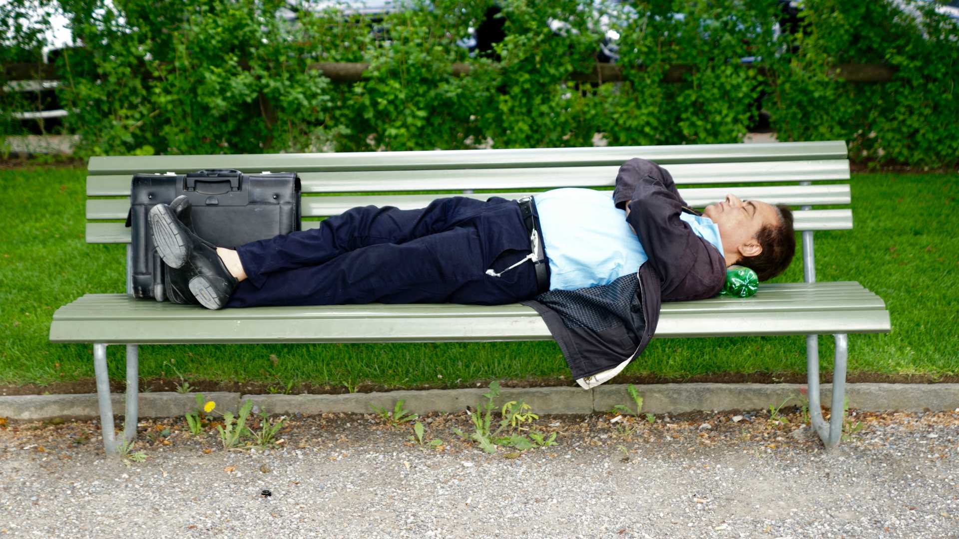 businsesman sleeping on a bench