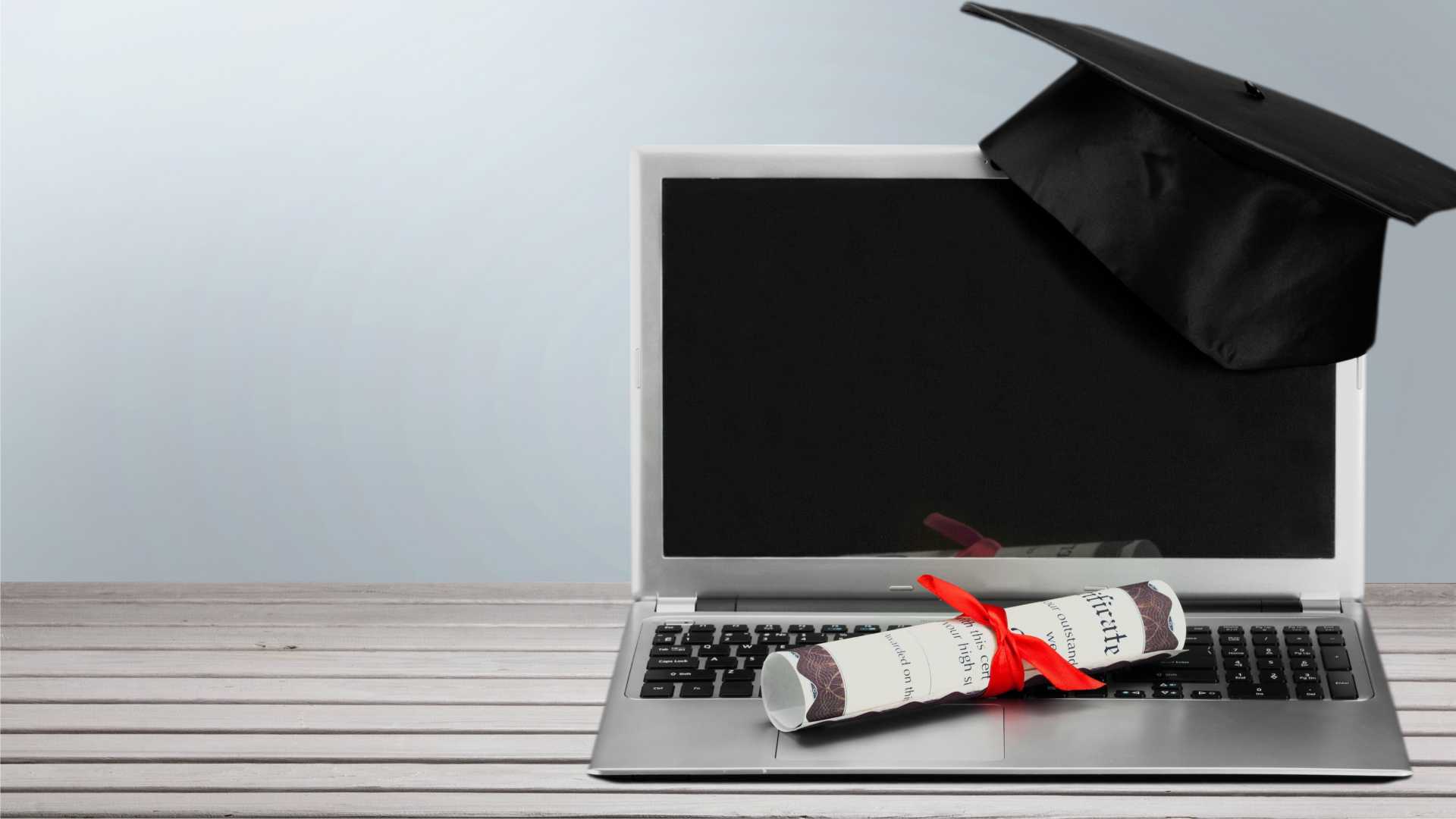 laptop with diploma and grad hat