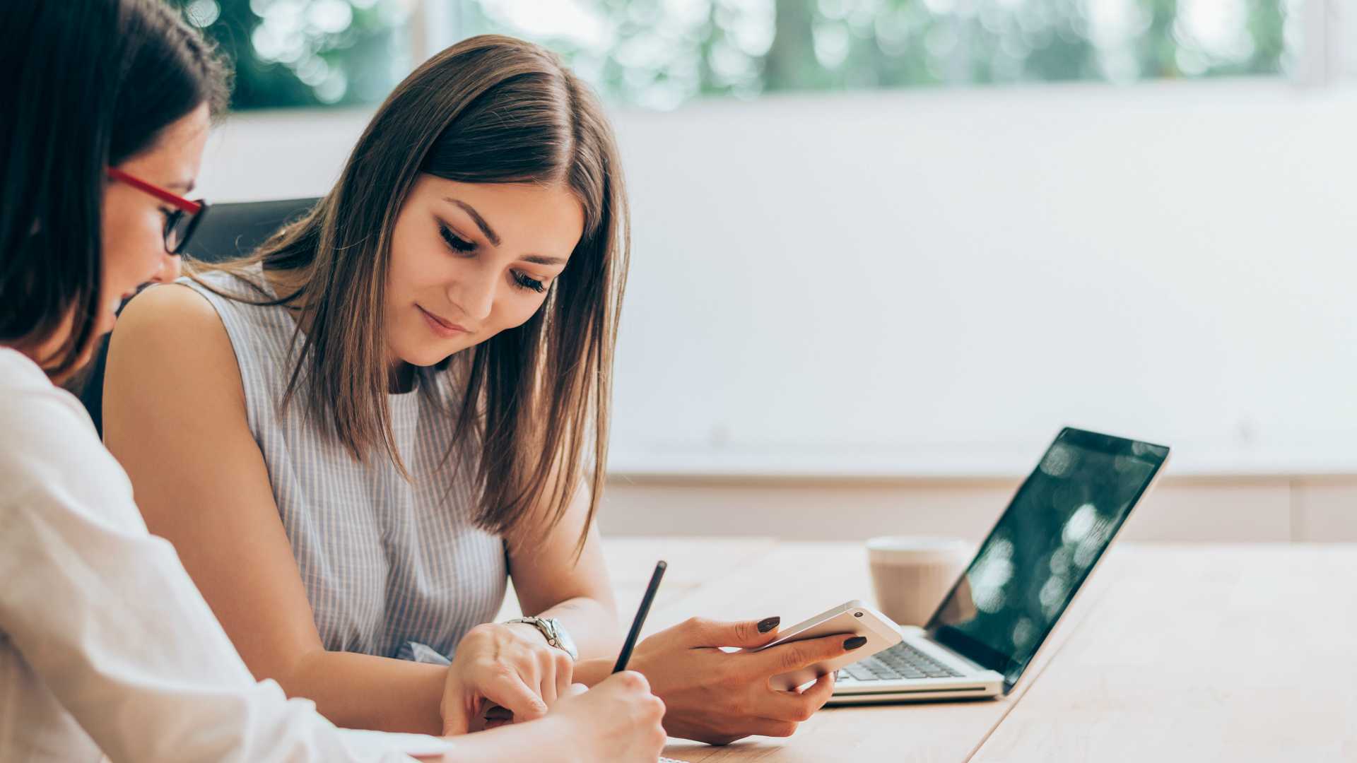 Woman coaching another woman with a laptop