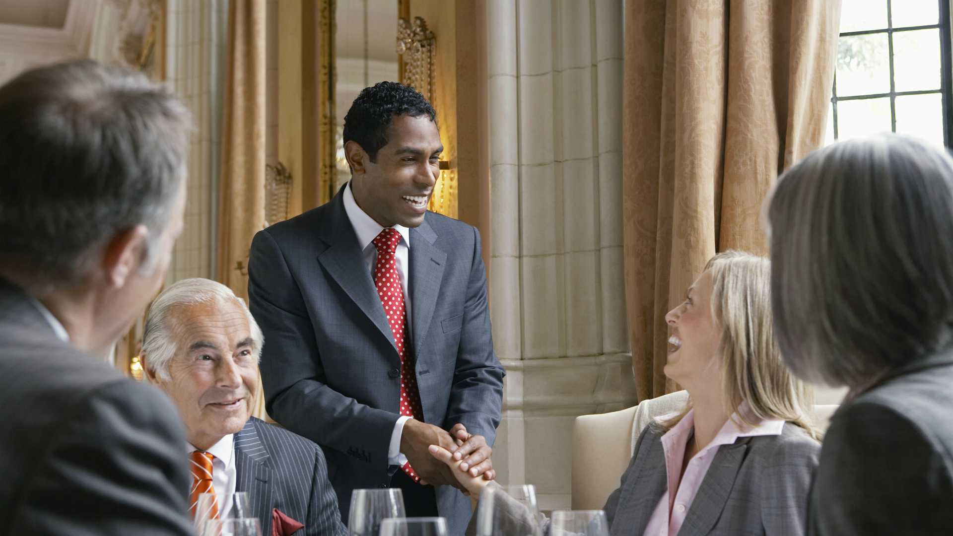 leader shaking hands with businesspeople