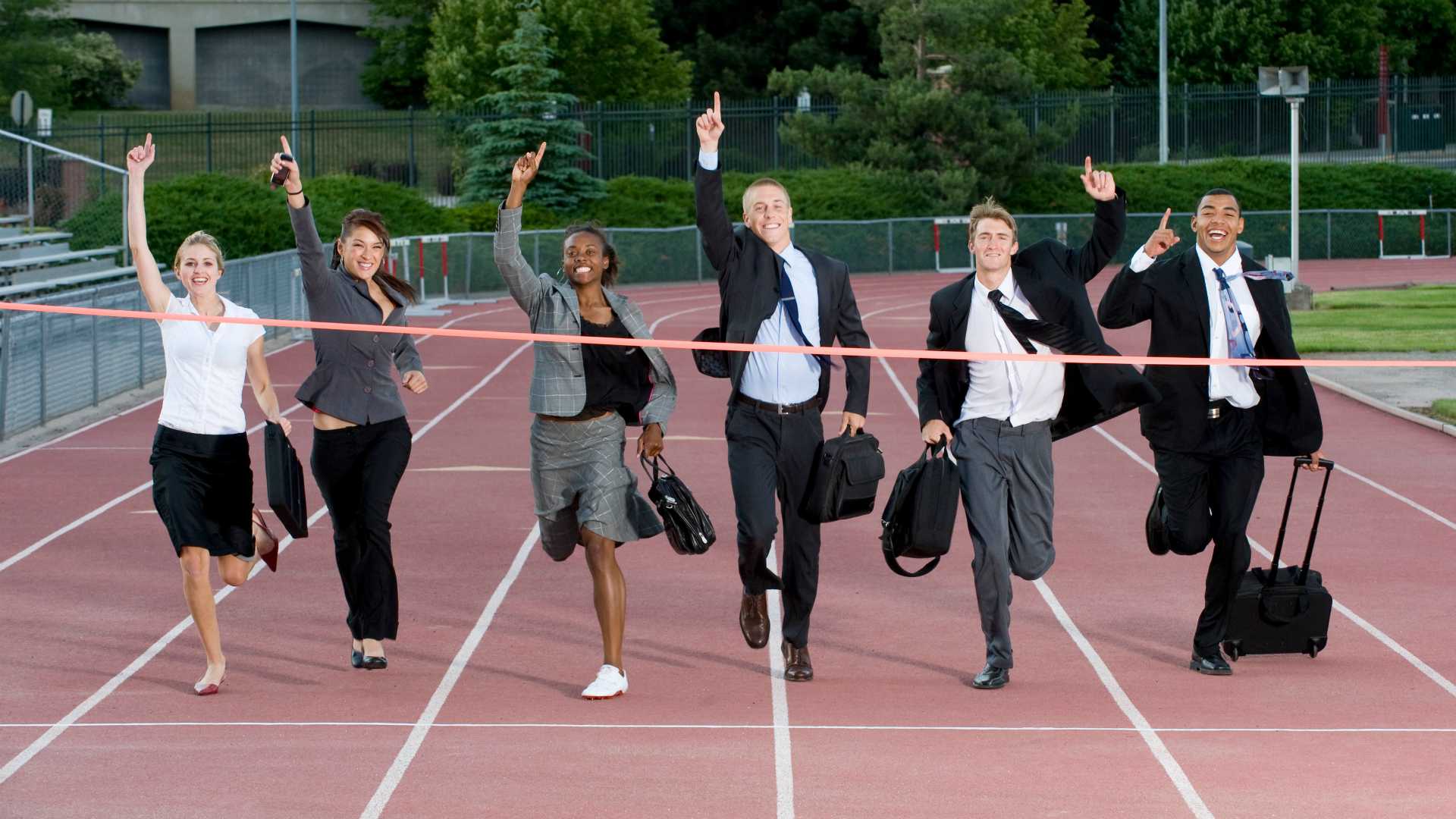 businesspeople running through a finish line