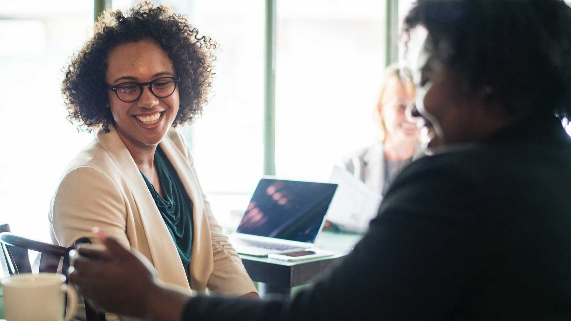women talking near a laptop
