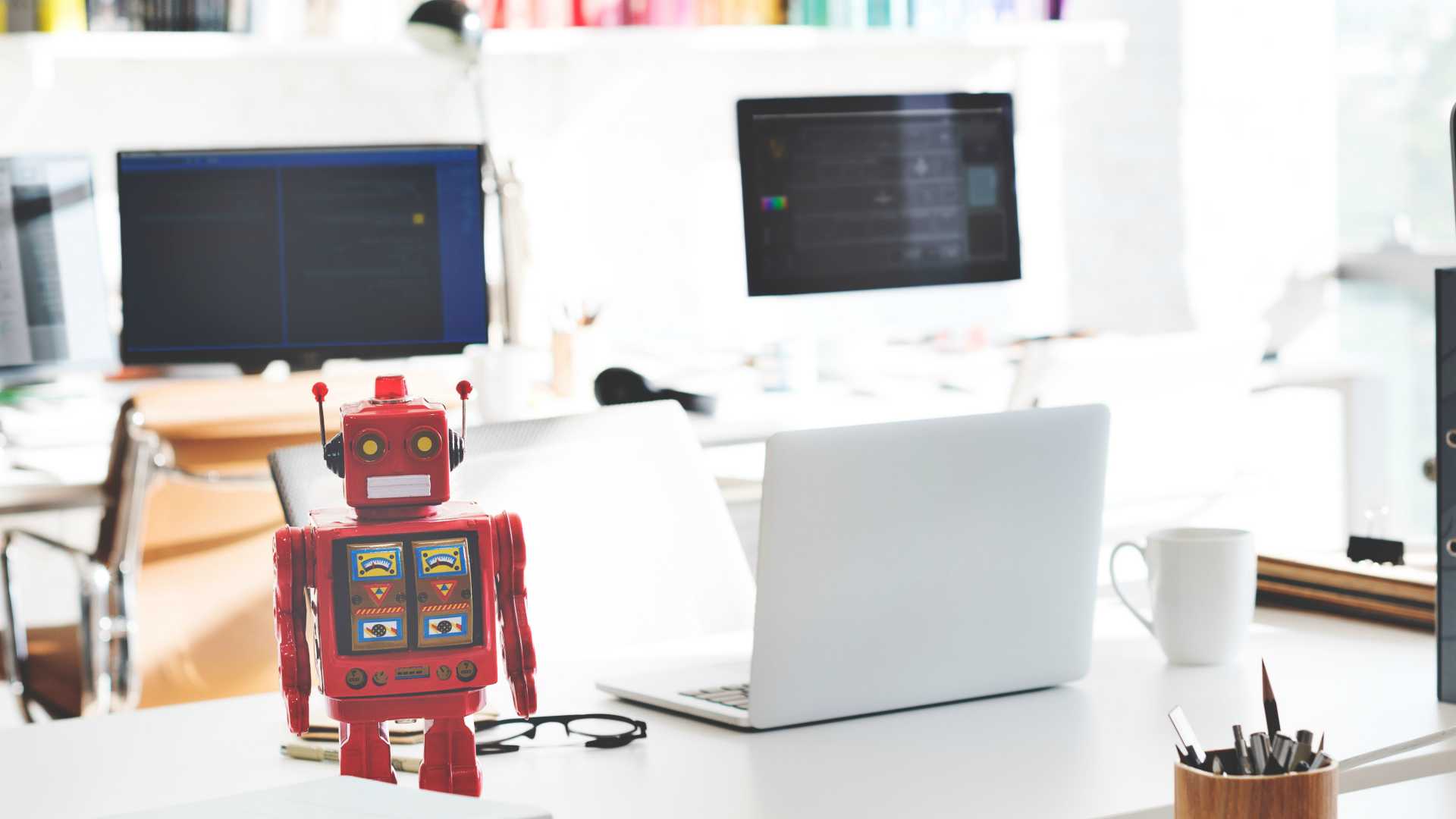 robot on a desk, computers with code