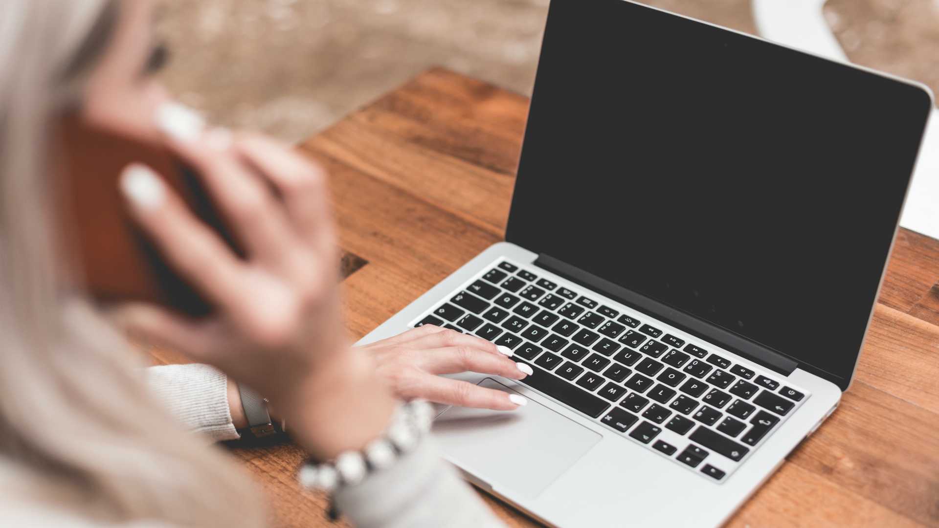 woman using a smartphone and a laptop