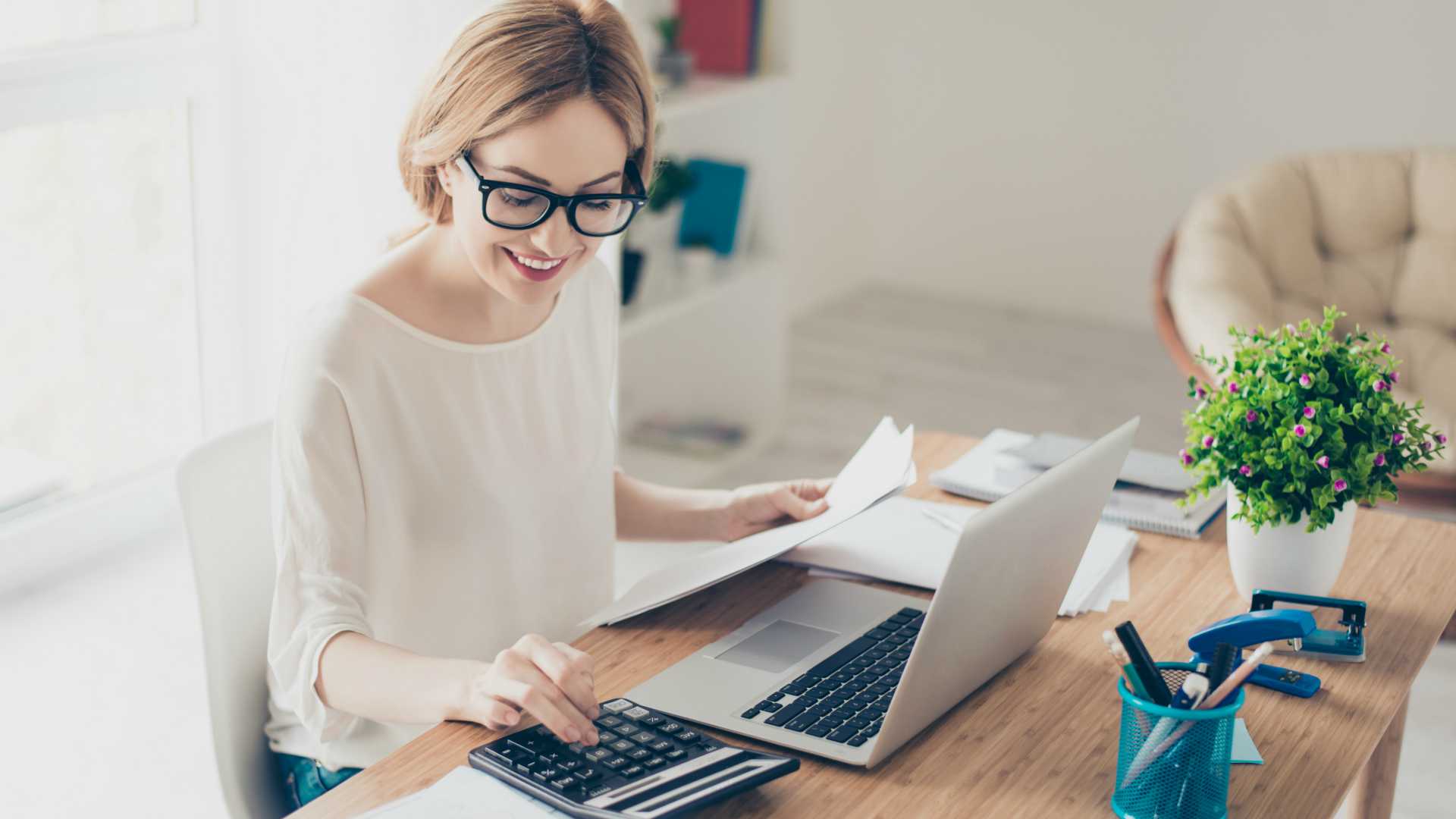 woman reviewing a document and using a calculator