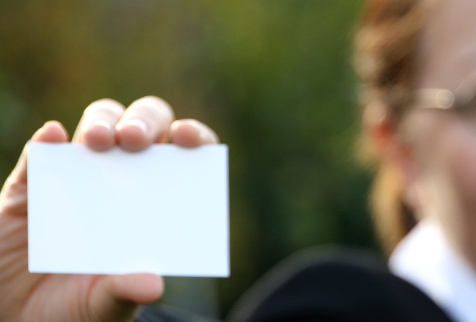 businesswoman holding up a blank business card