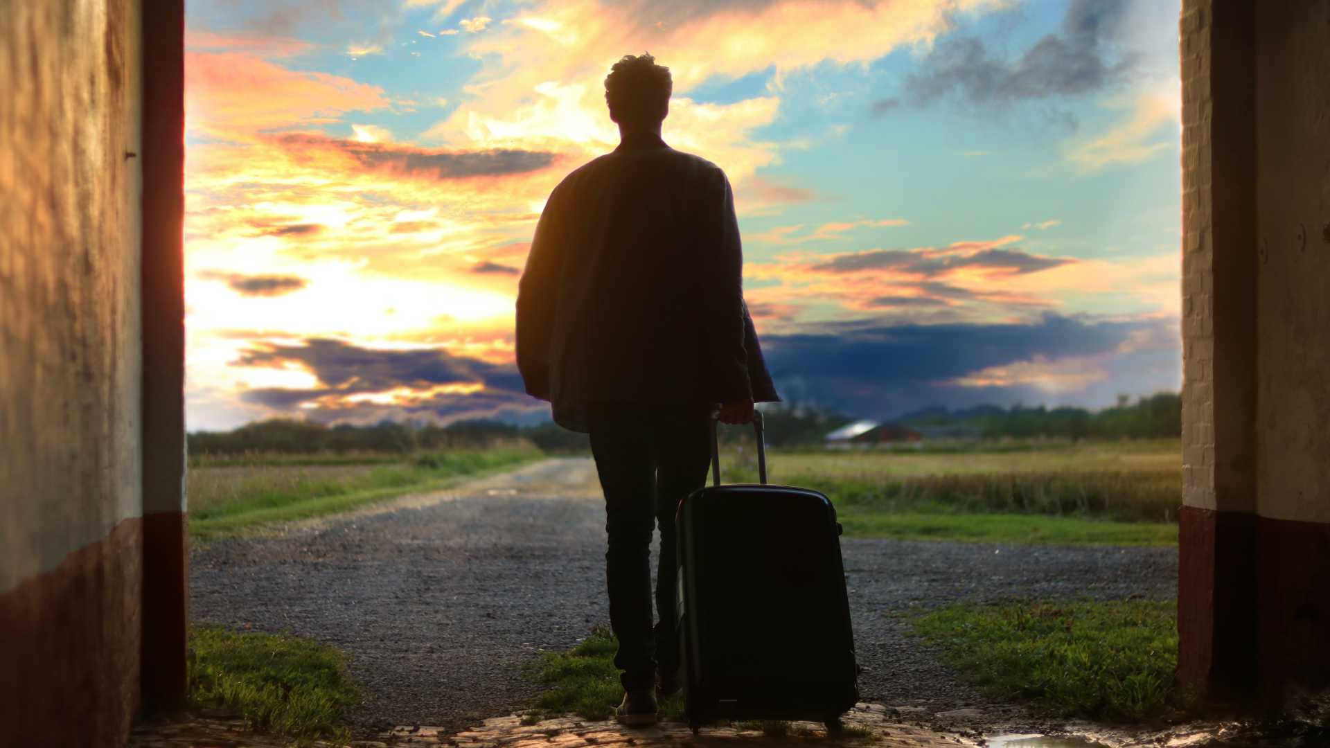 man setting out on a journey with a suitcase