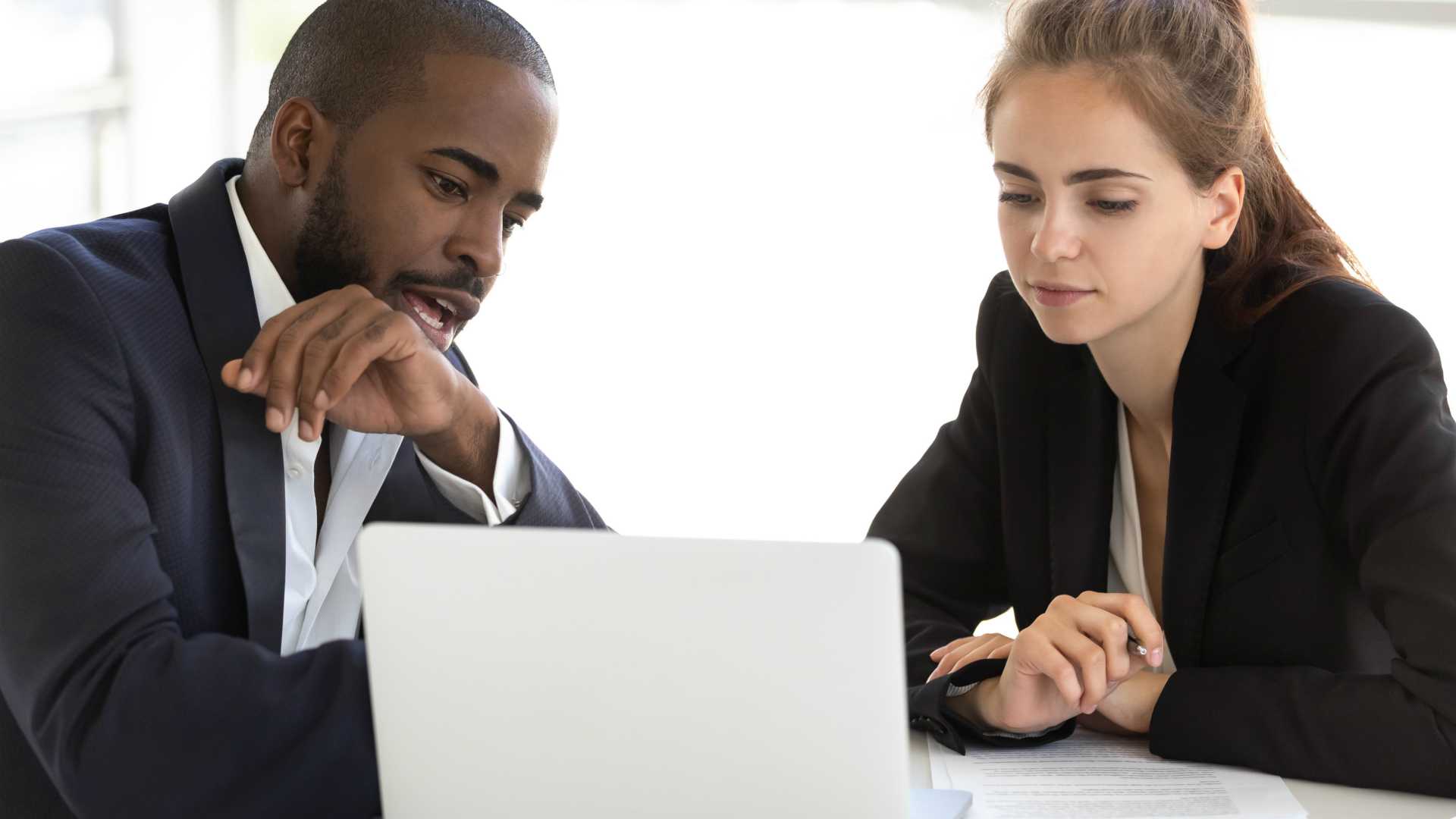 young black man and young white woman working together on a laptop