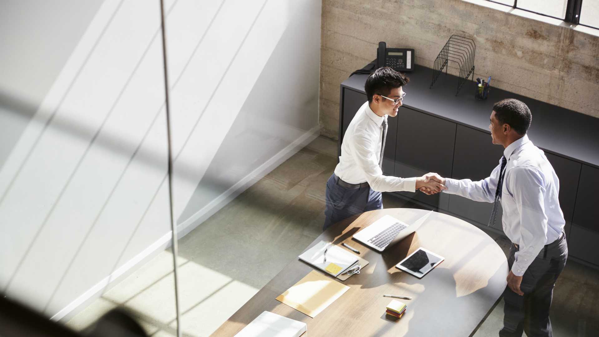 Aerial view of businessmen shaking hands after resolving a conflict