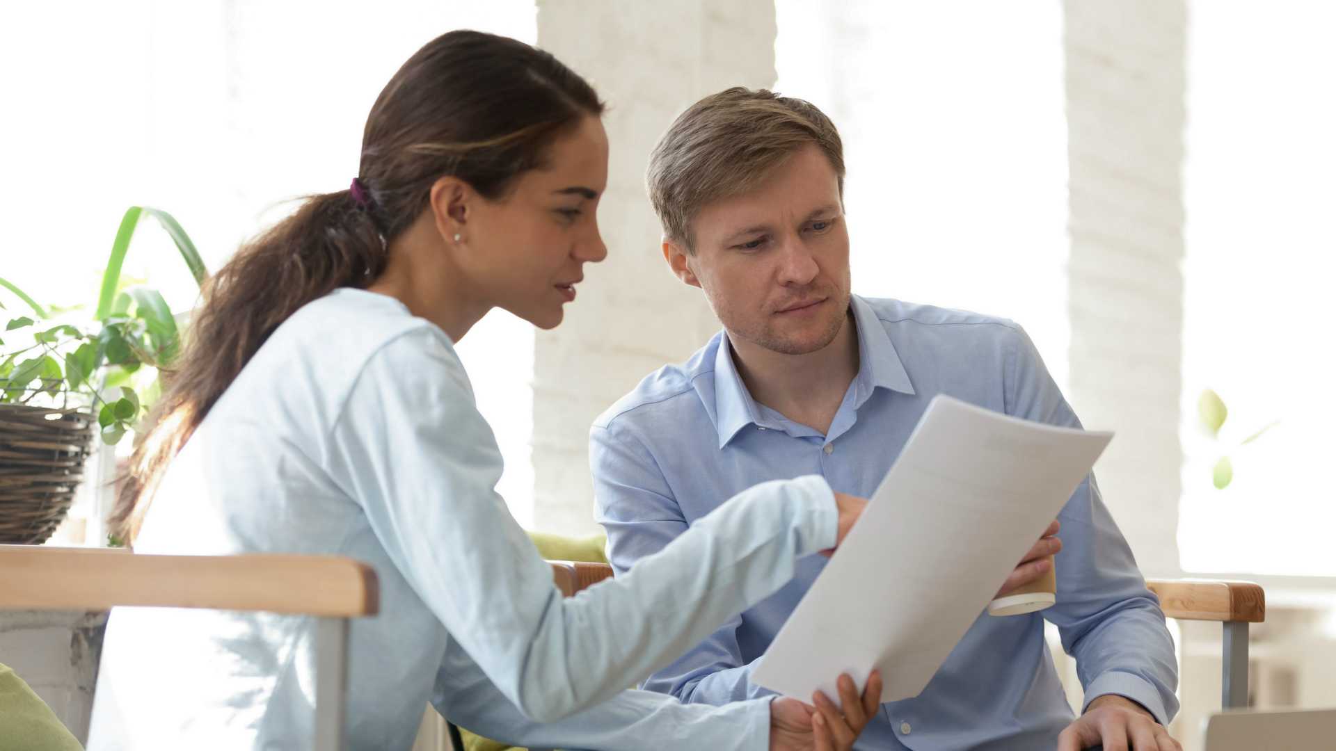 businesswoman and businessman looking over a document