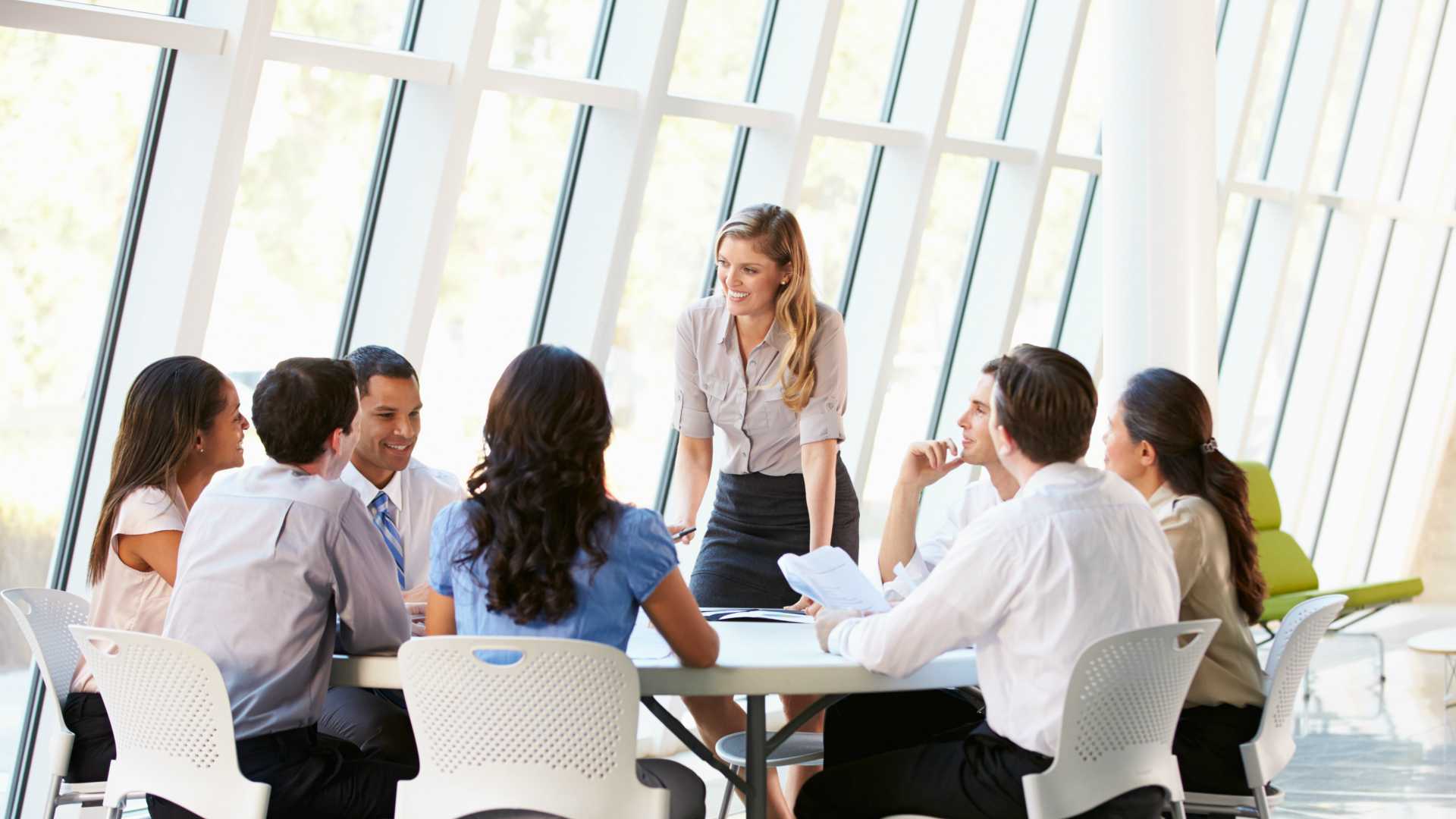 Diverse workforce gathered around conference table, discussing business strategy