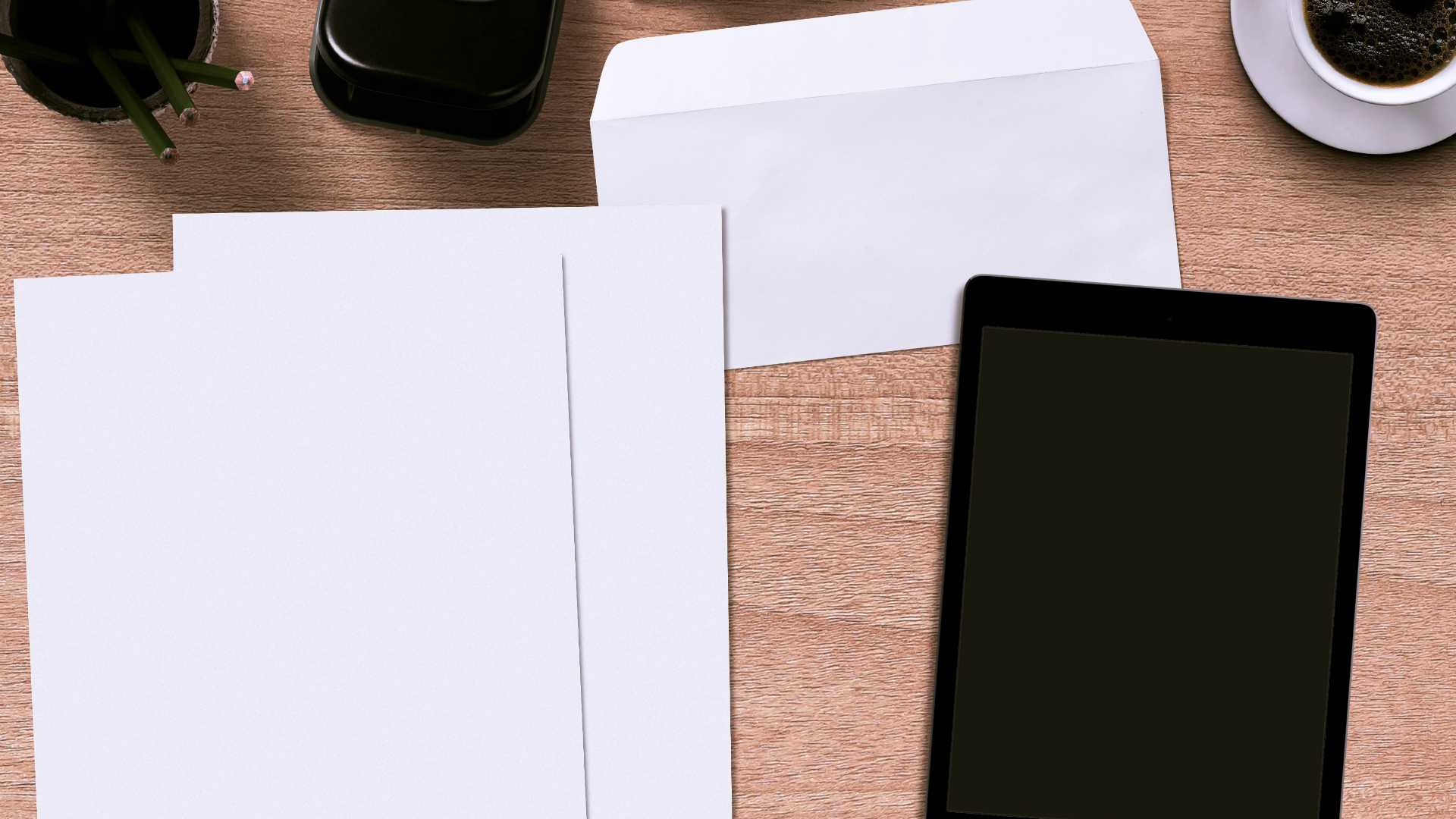 Aerial view of tan desk covered in forms and a tablet