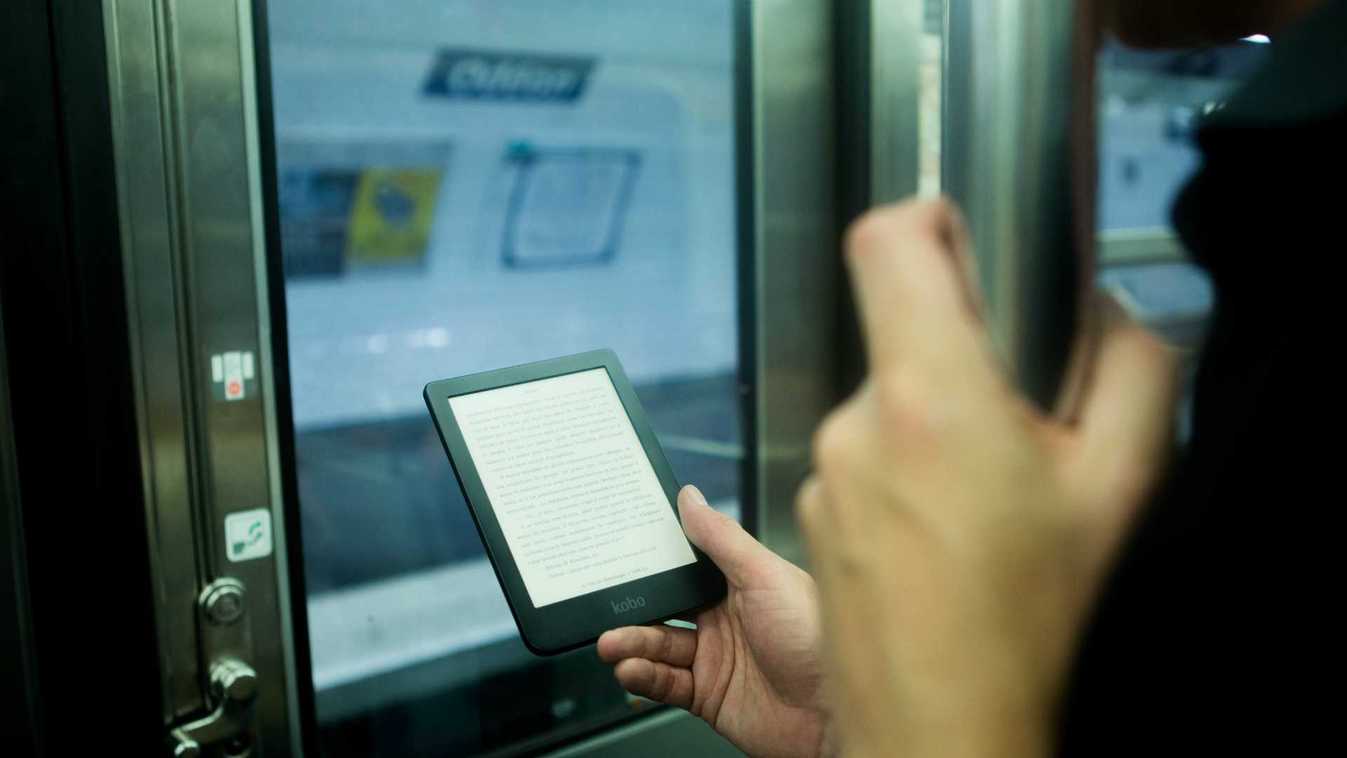Person on subway train reading on e-reader
