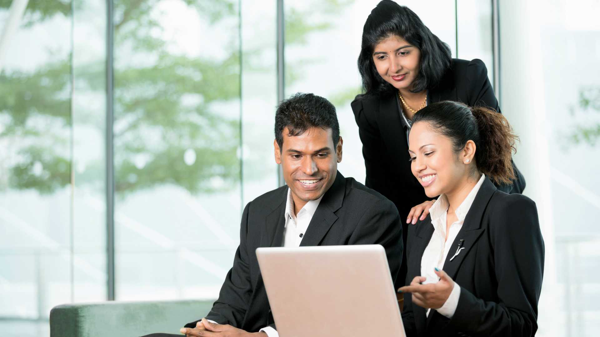 Indian Business colleagues working together around a laptop