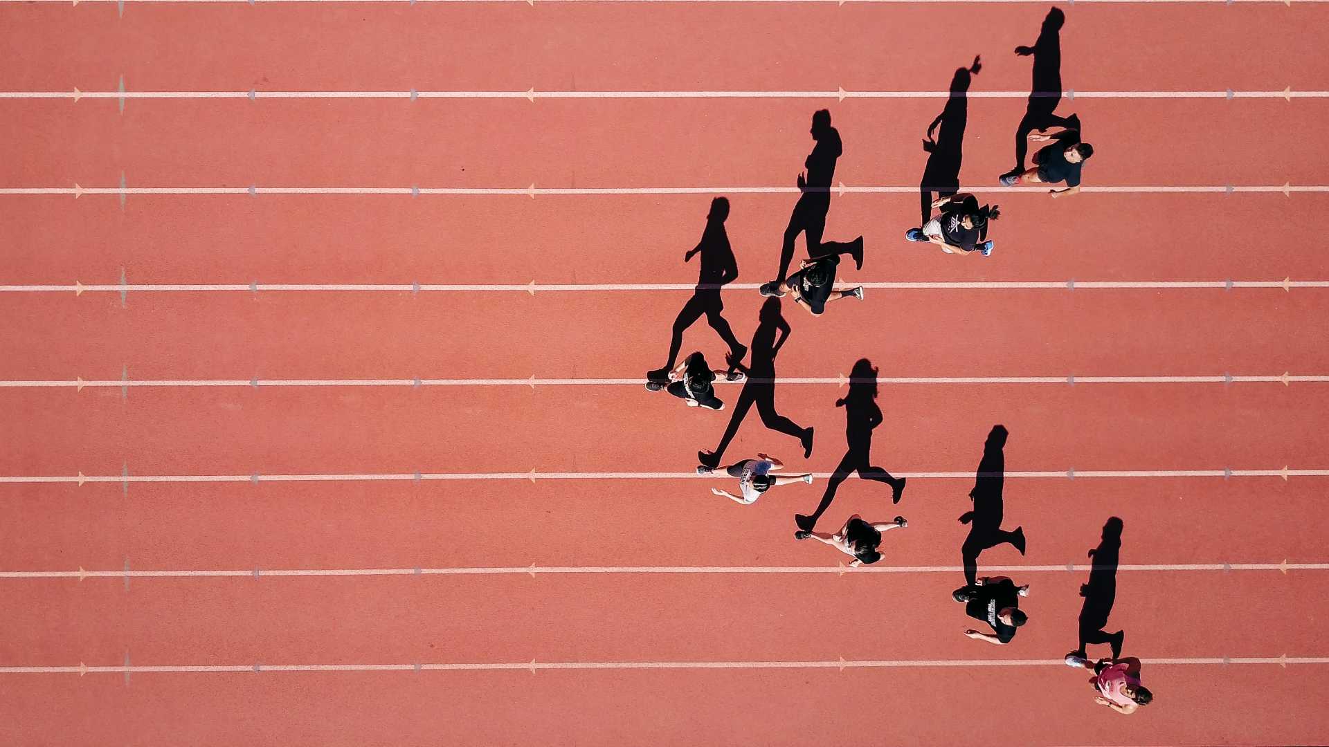 Aerial view of runners running in pyramid formation on outdoor track