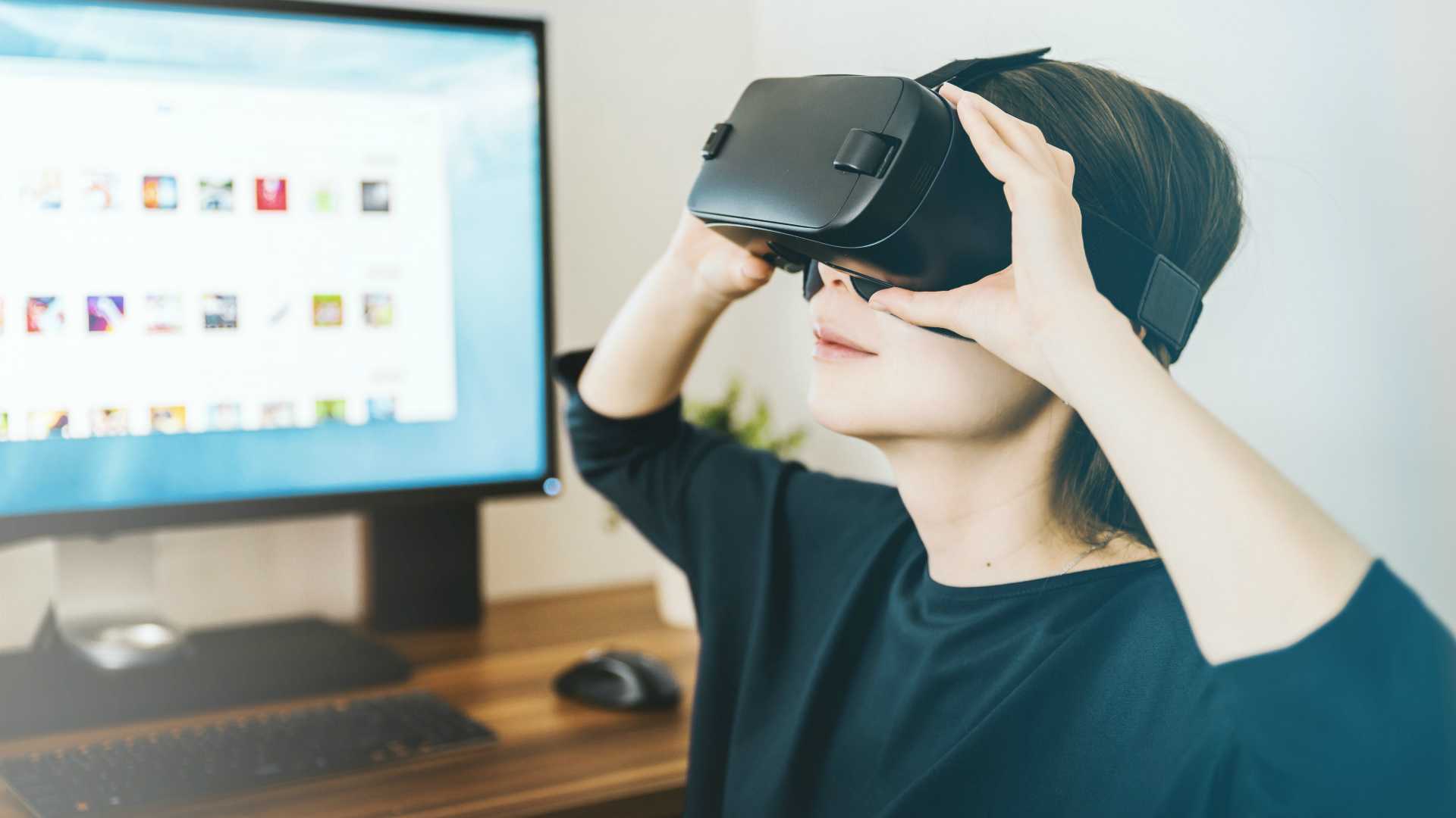Brunette businesswoman working from home and participating in immersive training program with VR headset on