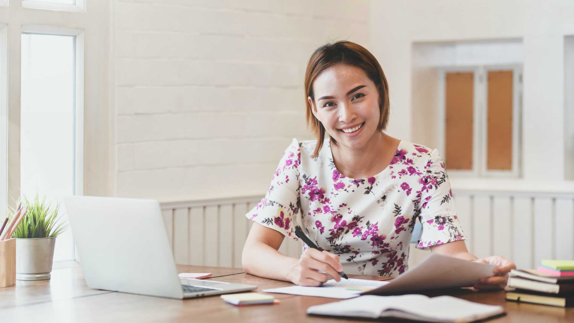 Beautiful, young businesswoman smiling for camera at workplace