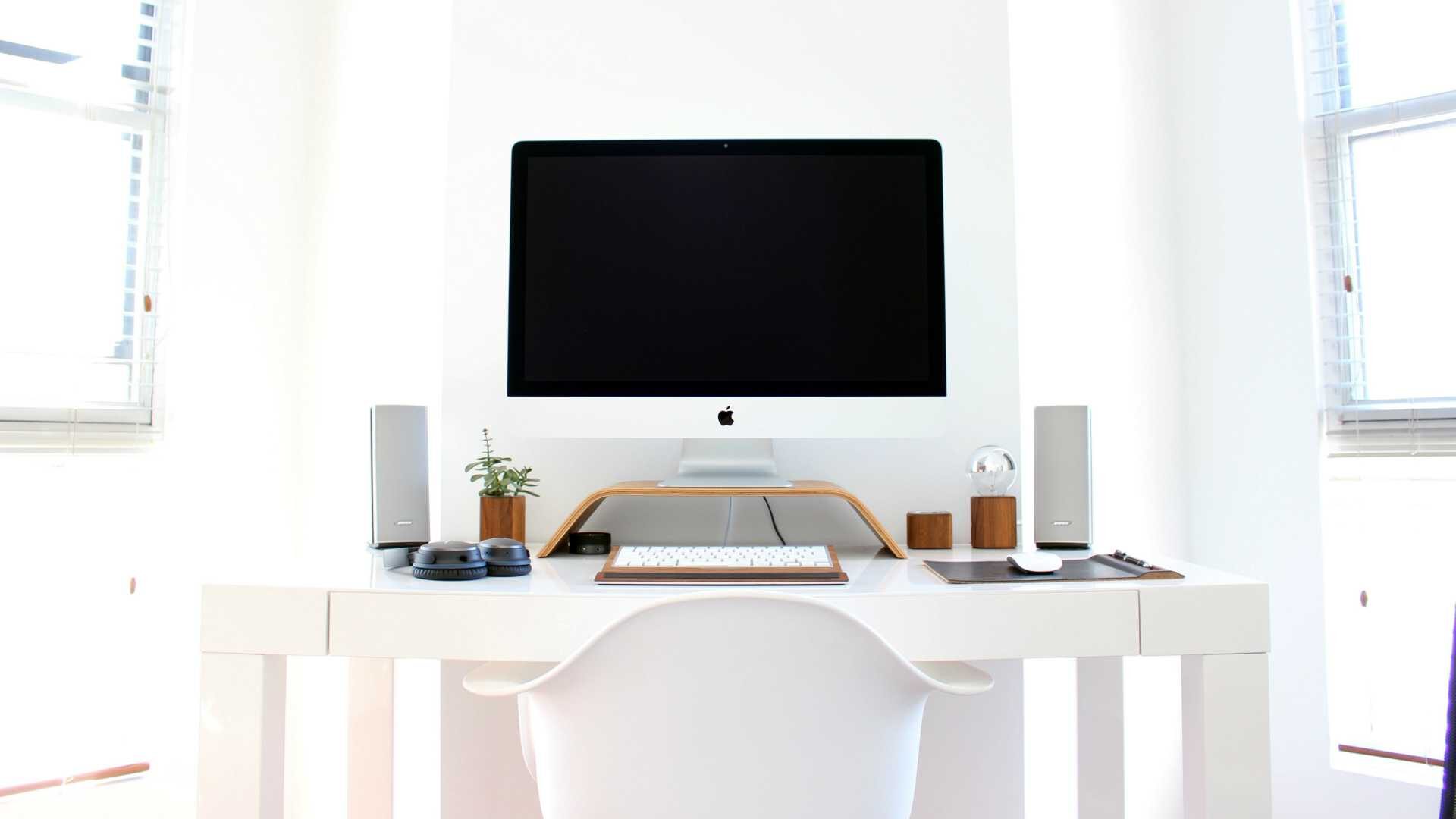 White Apple desktop computer in well-lit white home office