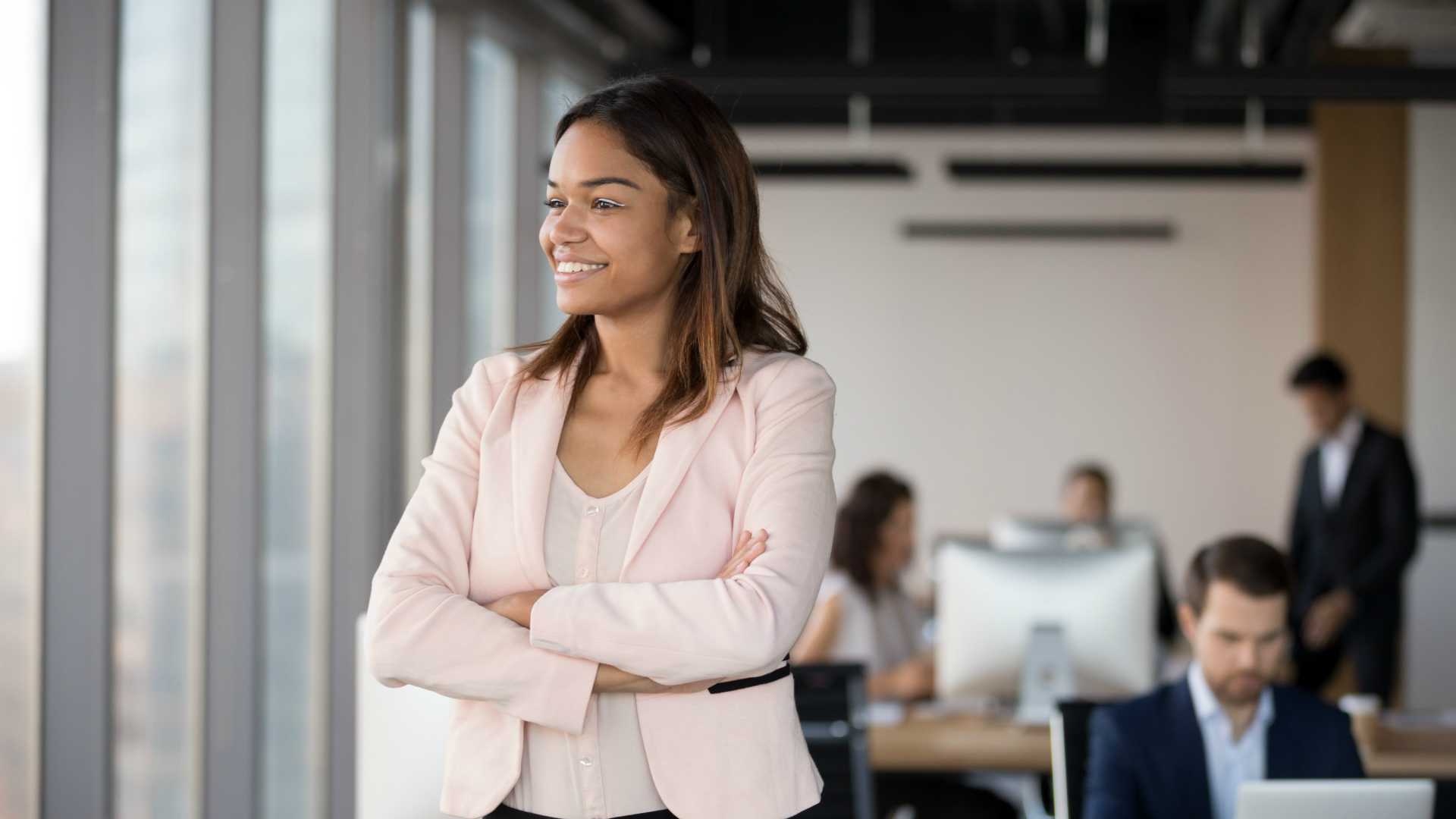 Happy biracial millennial office employee stand looking in distance dreaming of future work achievements