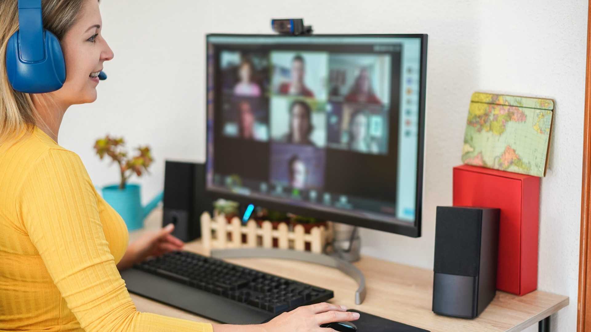 Young woman having a discussion meeting in video call with her team - Girl making webinar lesson using headphones with microphone on pc web app - Technology and smart work concept - Focus on hand