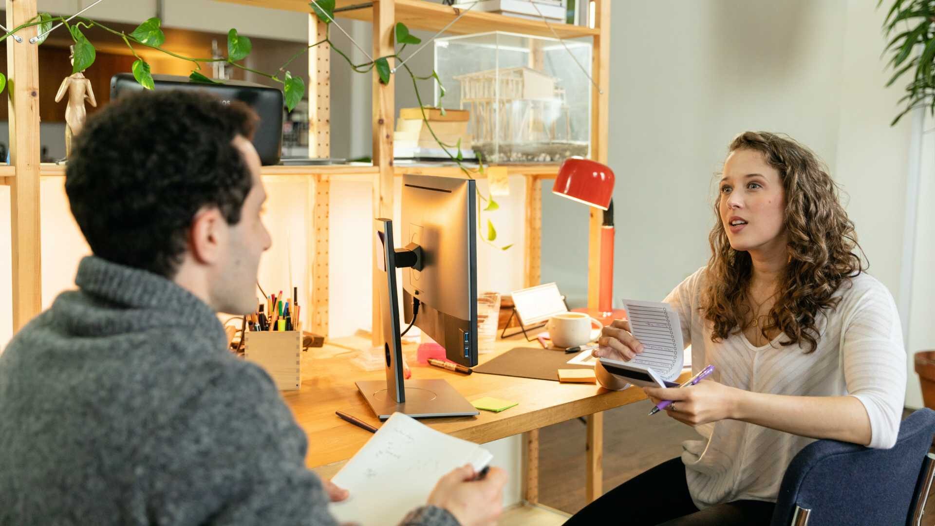 Two people talking at desk