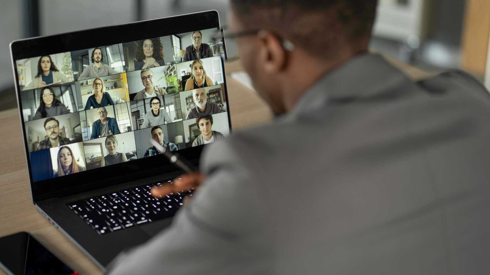 A man participates in a virtual meeting with colleagues.