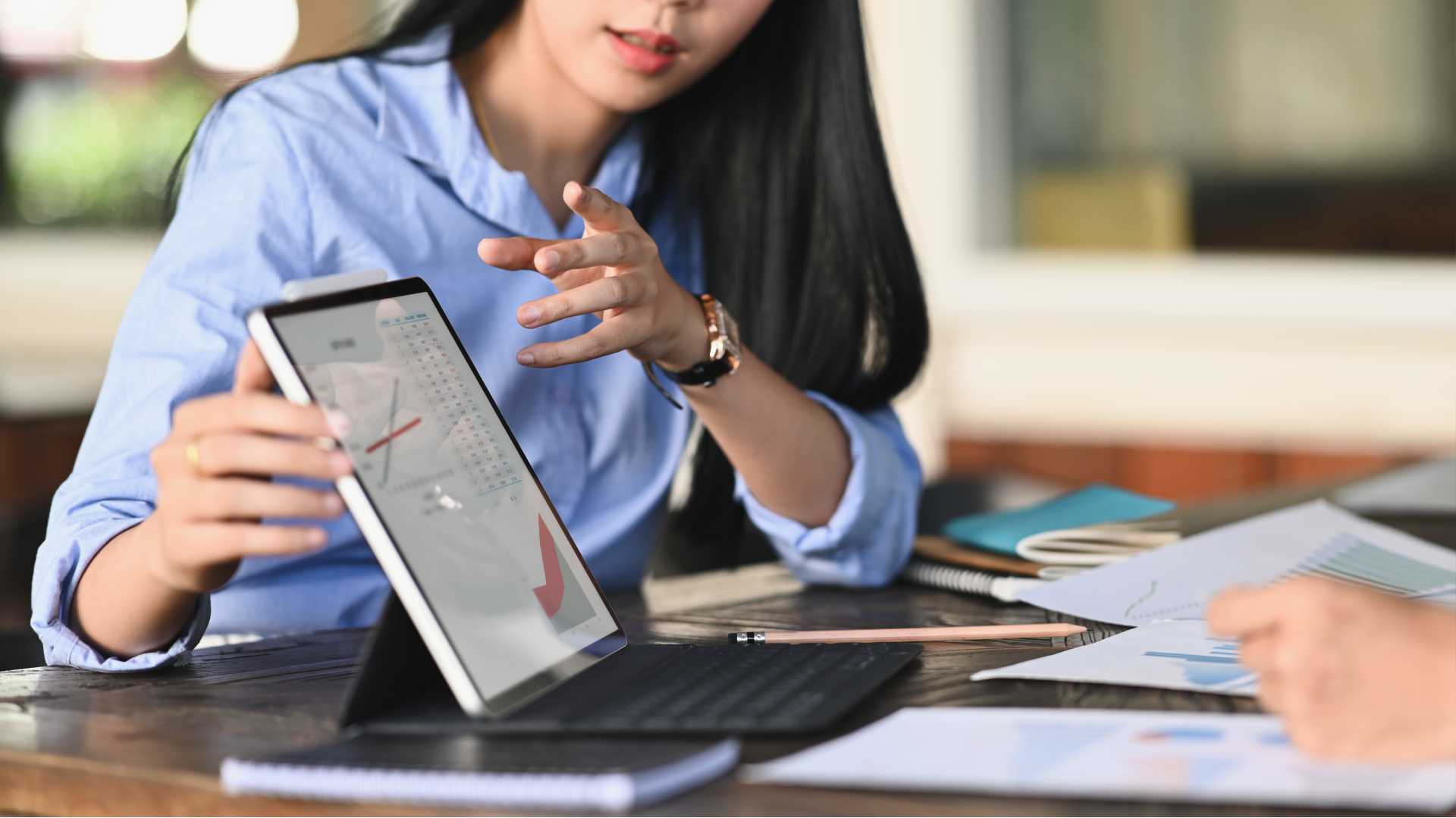 a woman gestures to a laptop screen that is pointing away from her, demonstrating some cybersecurity issues for a software developer in training.