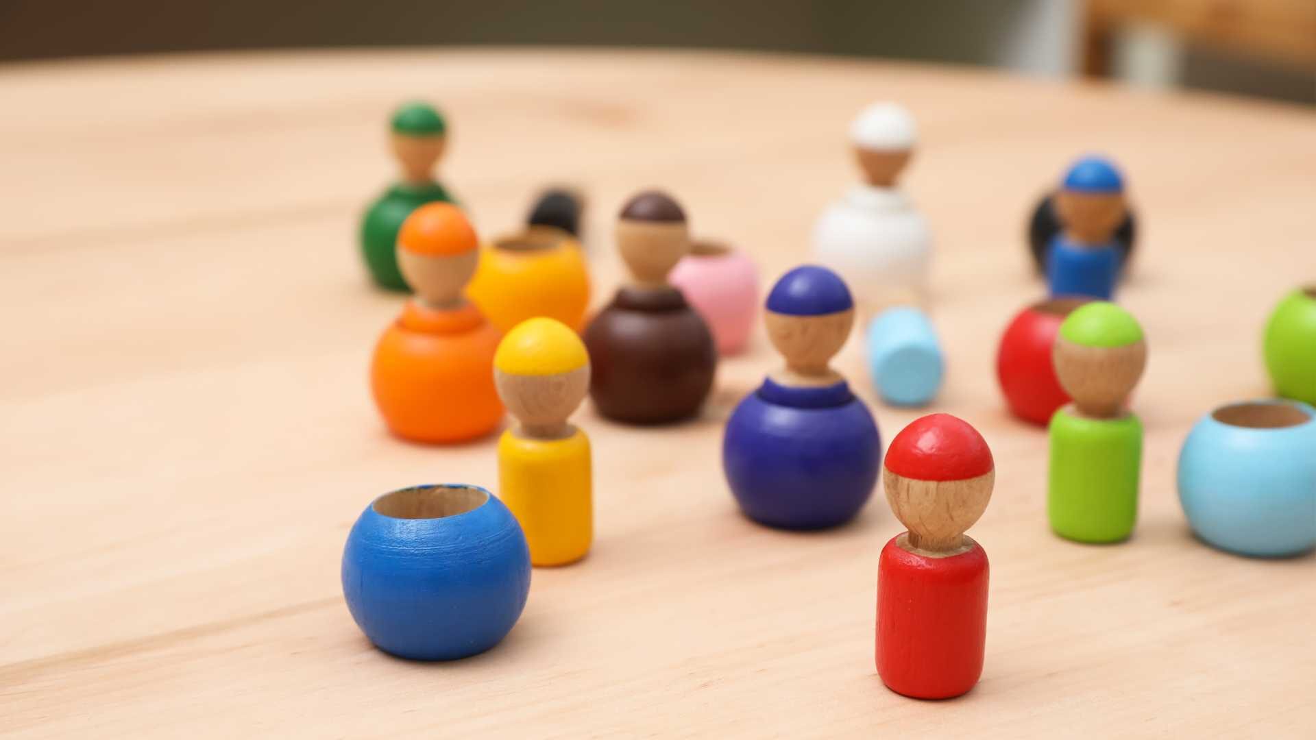 Miniature, toy people carved from wood in an array of colors.