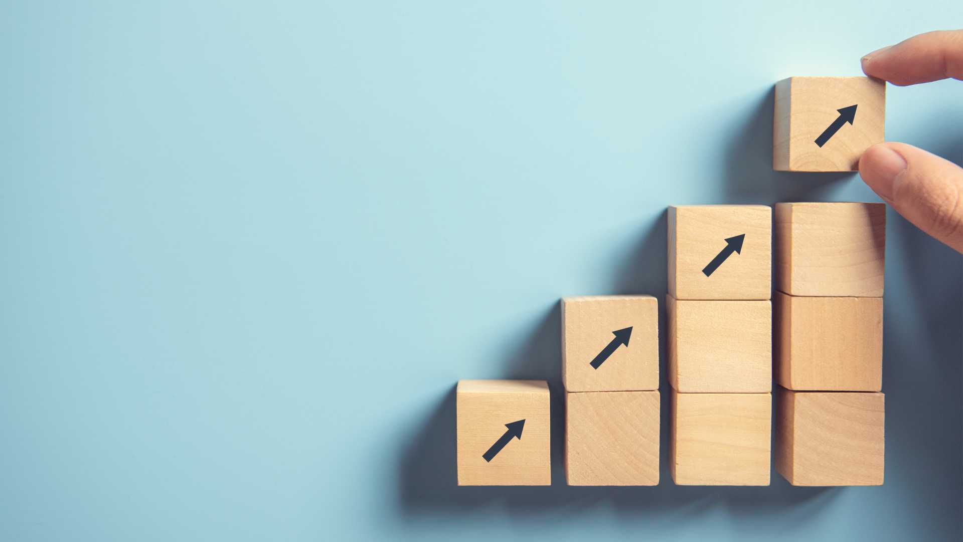 Wooden blocks are stacked like stairs with arrows pointing upward