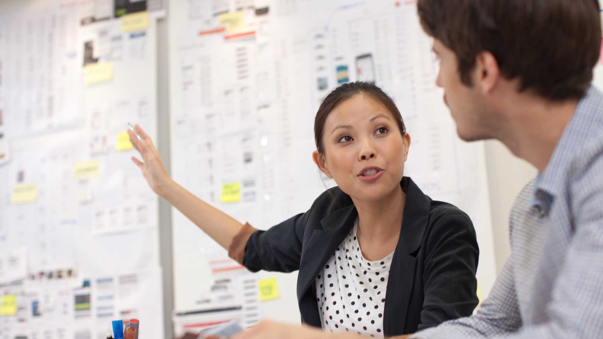 A businesswoman explaining a chart with graphs and statistics