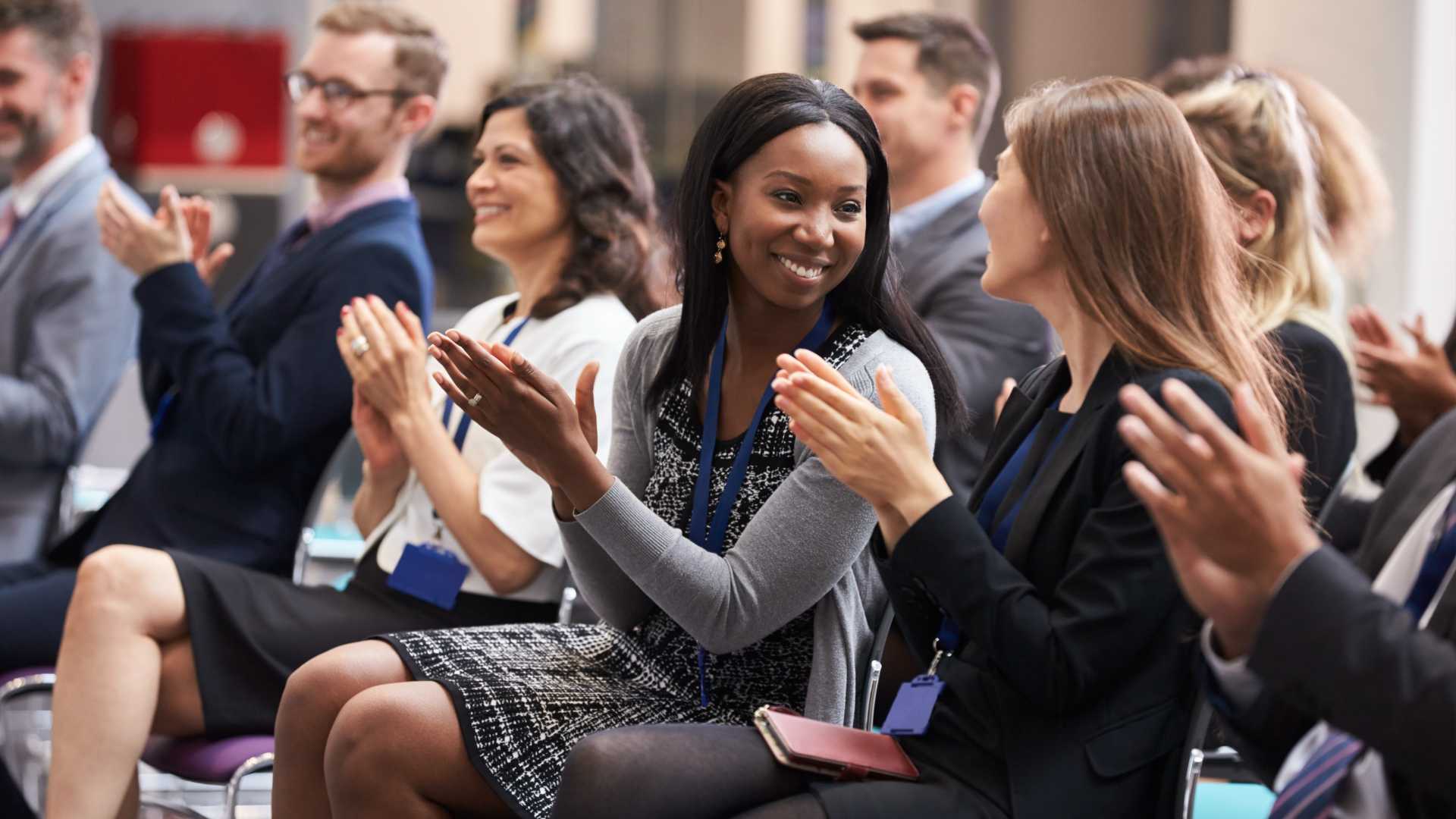 Large group of learners learning in a conference style training session/ traditional classroom training in-person.