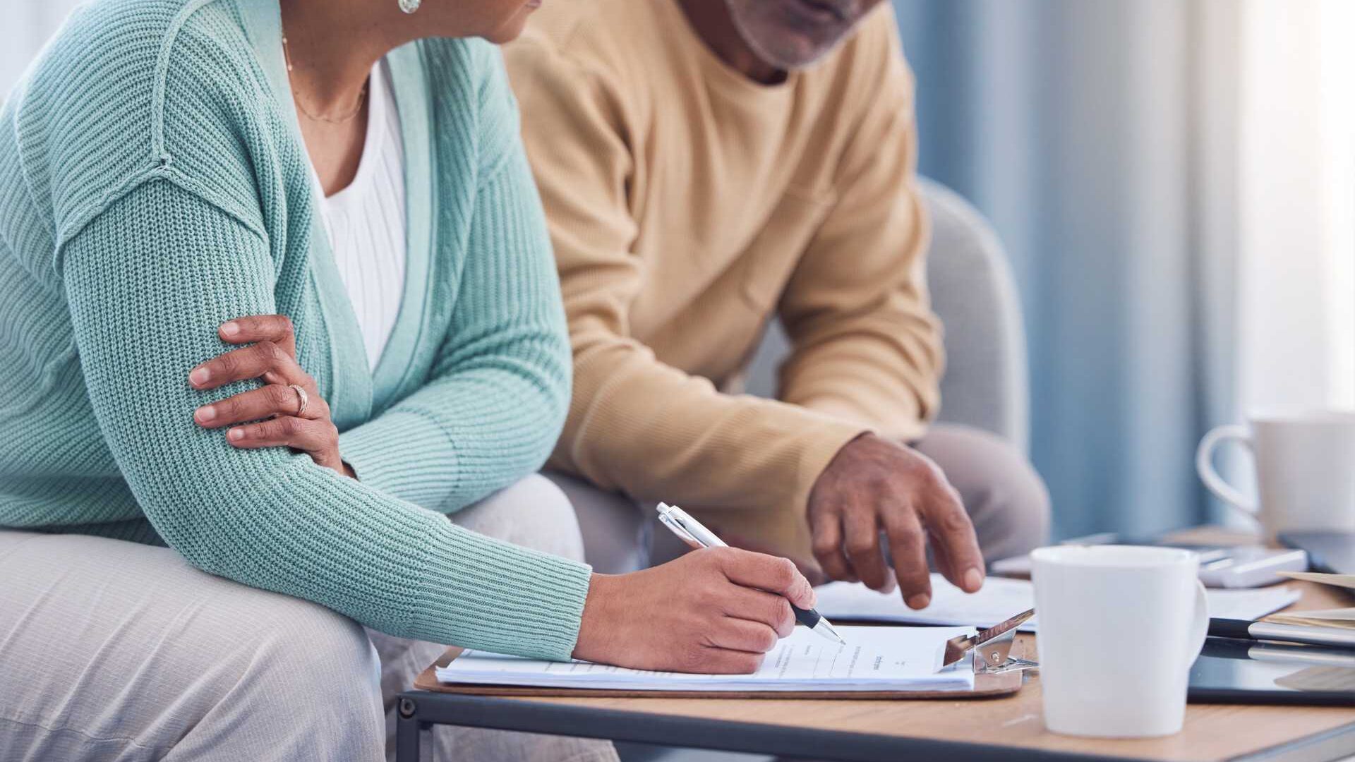 Woman and Man looking at documents together while sitting on a couch.