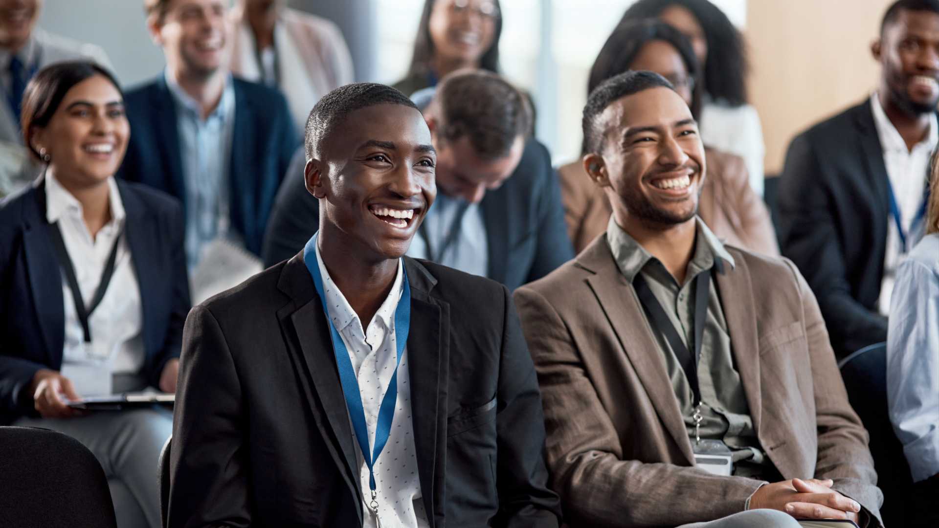 a group of employees are all sitting in a classroom setting laughing