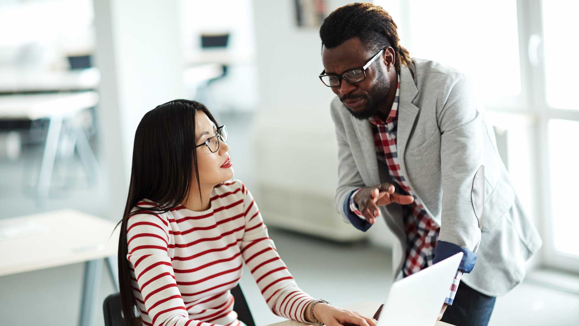Woman speaking with her male coworker regarding a project.