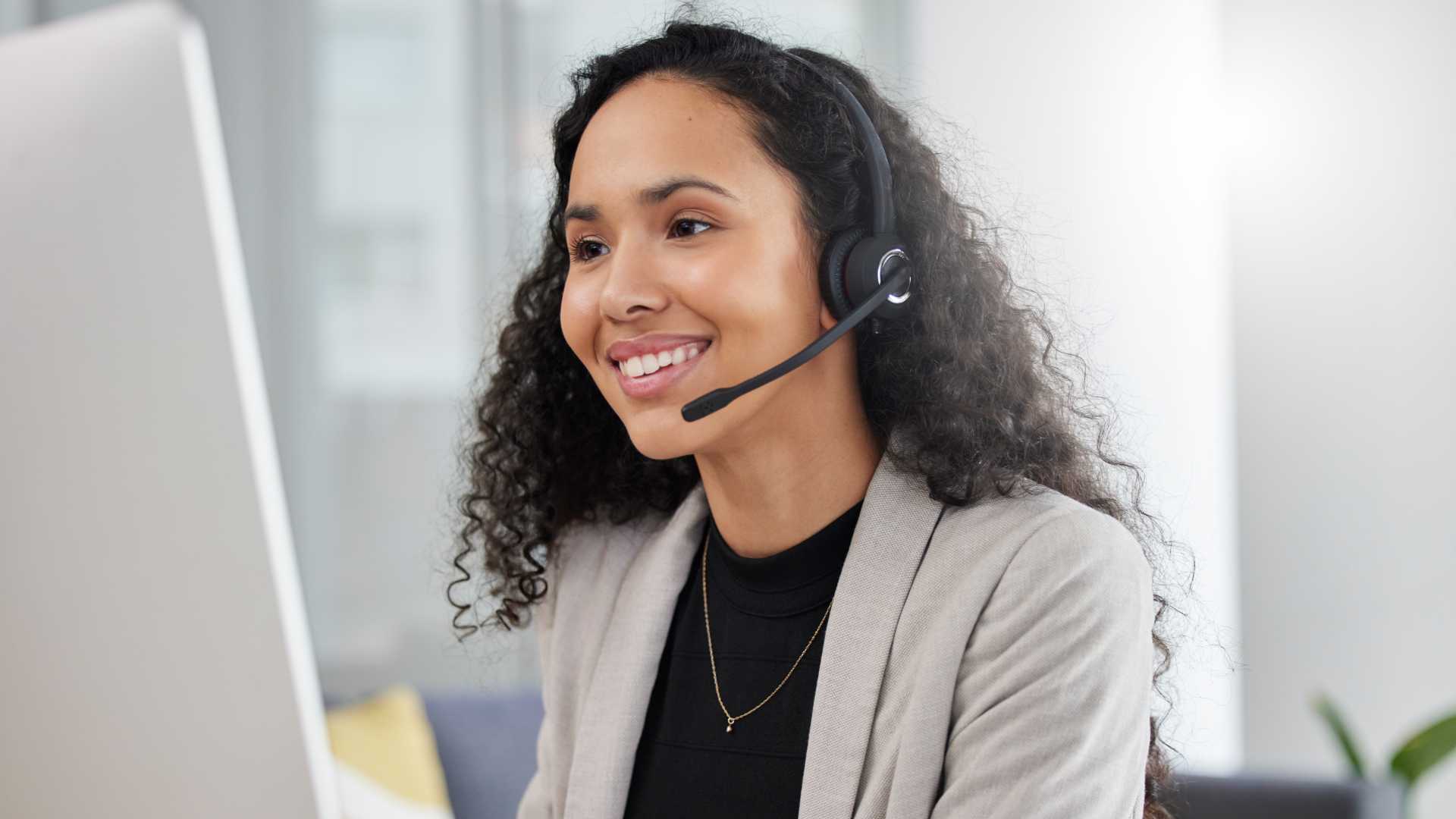 Woman looking doing calls at her desk.