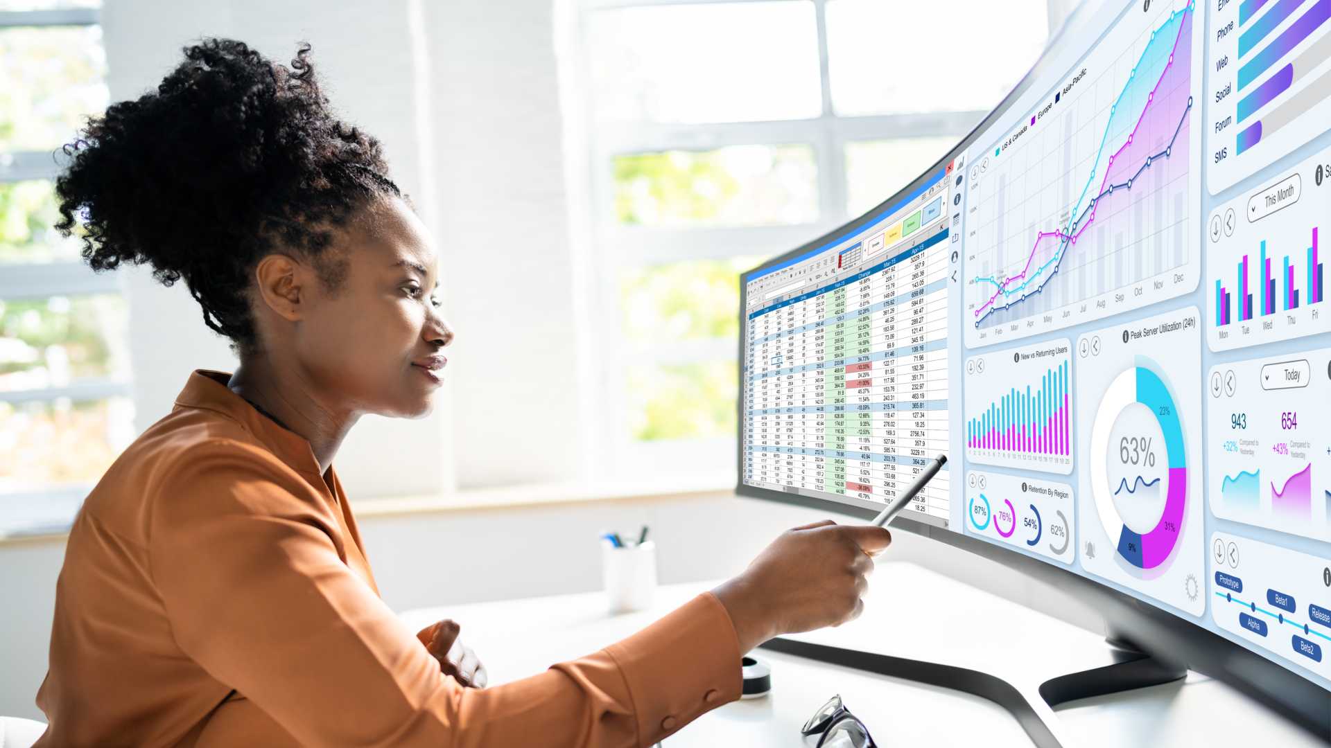 Woman looking at graphs on her monitors.