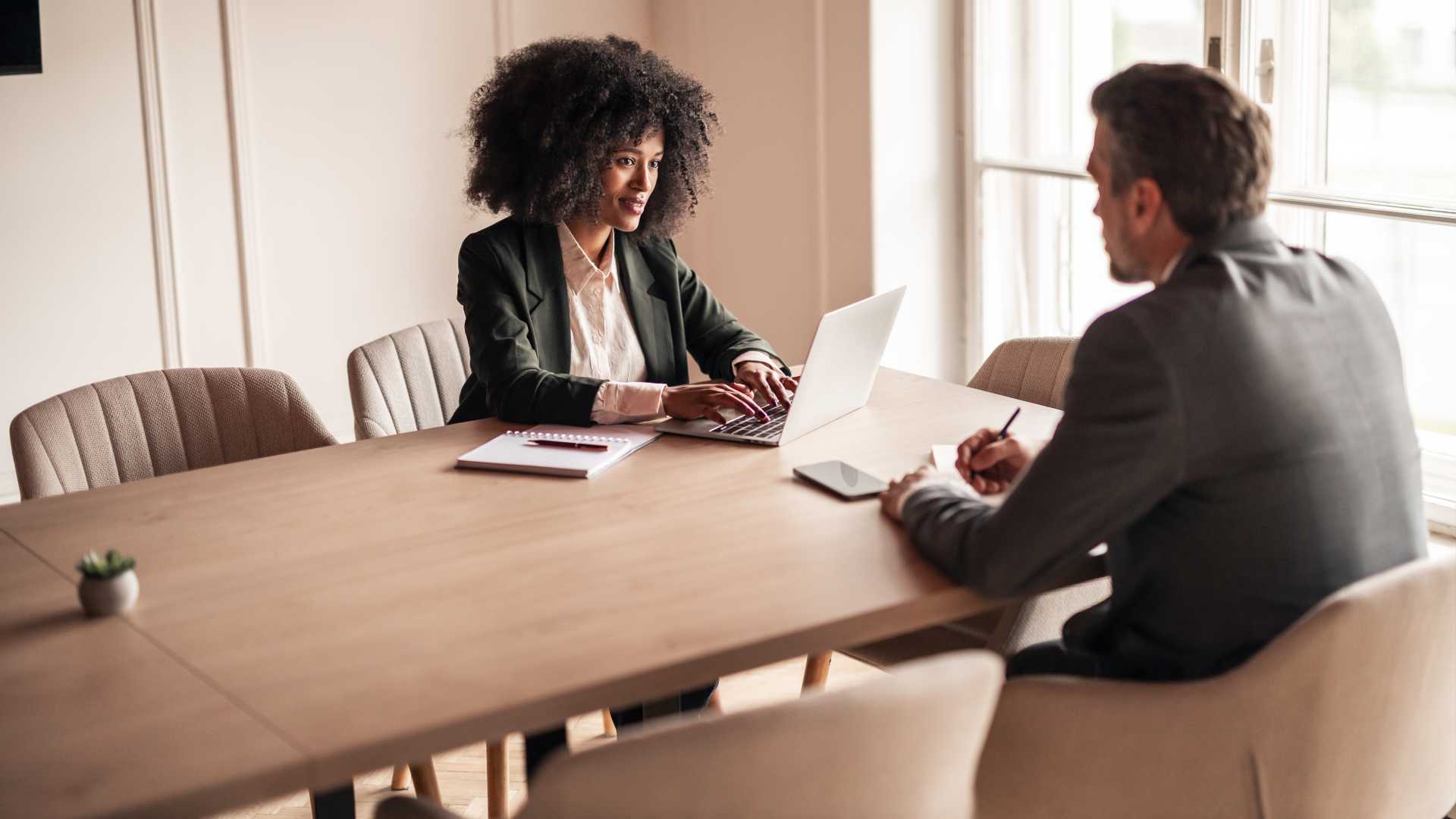 Two businesspeople sitting across from each other at a table.